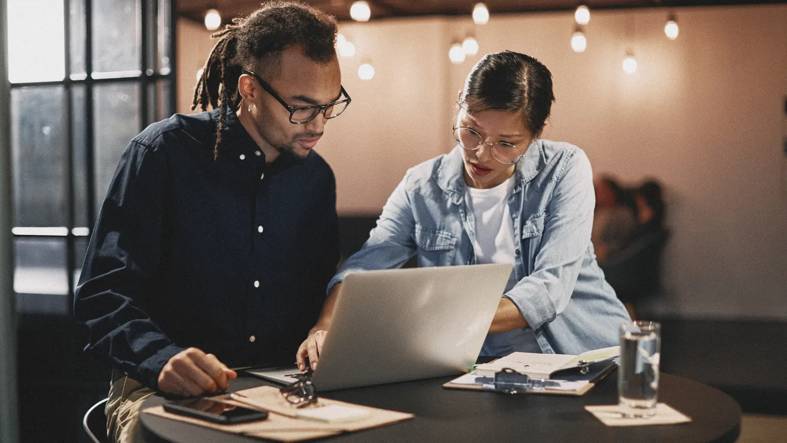 Two designers working together at a laptop in a studio: outsourcing web design and branding to a studio in Morocco