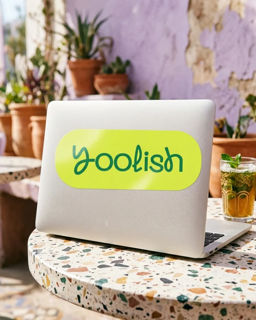 ملصق Yoolish ليمي على حاسوب فوق طاولة مقهى من التيرازو