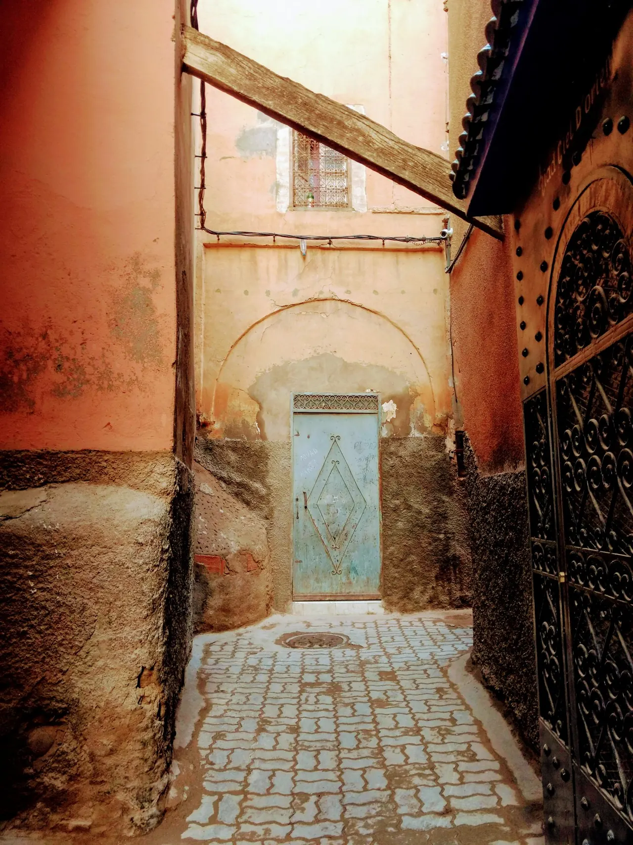 A winding medina alley leading to a decorated door